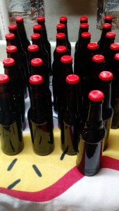 Boring pic of red capped bottles of black IPA